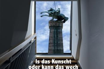 Ein Reiterdenkmal wächst aus dem Dachfenster