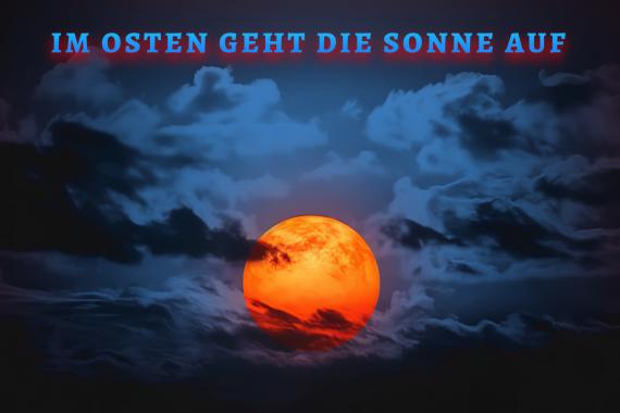 rote Sonne vor blauen Wolken